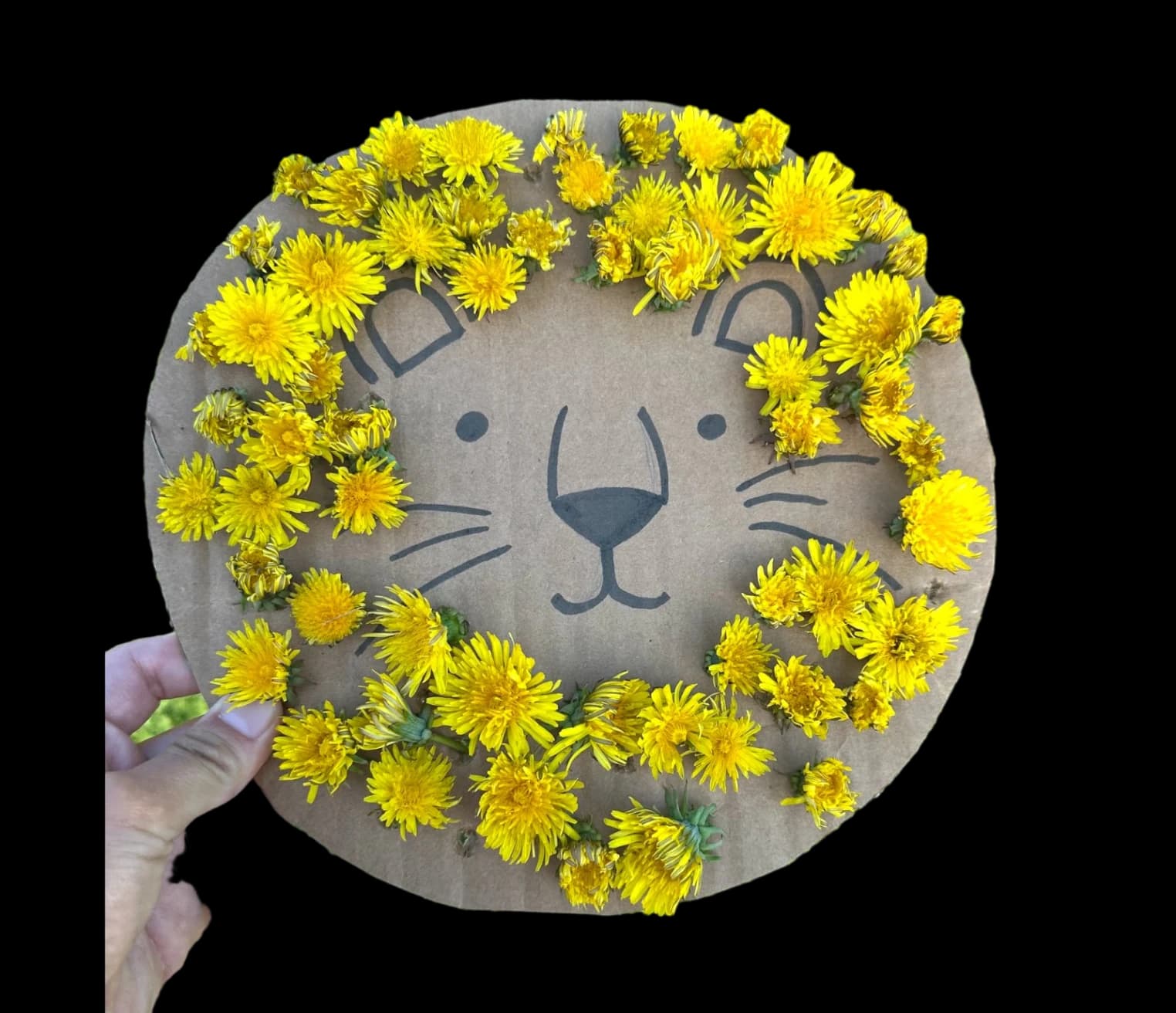 A handmade lion with a mane of yellow dandelions